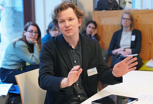 Anton Kolomieitsev, Fachworkshop "Vermessung der Zerstörung" in Leipzig 2025, Foto: Klaus Michael/Sächsische Akademie der Künste 2025 Anton Kolomieitsev am Tisch sitzend und erklärend